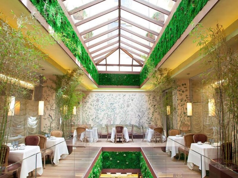 O restaurante tem uma parede verde e uma clarabóia com iluminação natural Foto: Divulgação