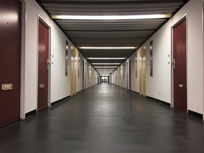 Um dos corredores do prédio, onde se pode ver os diferentes tipos de portas: Para entrada, serviço, medição e portinhola Foto: Laura Ammann